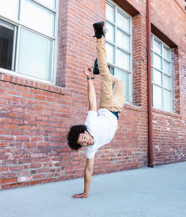 Man performing a controlled strength exercise in a bright room.